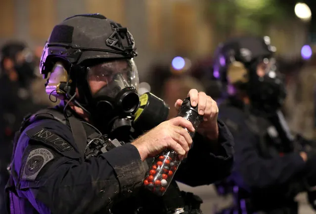 A federal law enforcement officer holds pepper balls during a protest against racial inequality and police violence in Portland, Oregon, U.S., July 28, 2020. (Photo by Caitlin Ochs/Reuters)