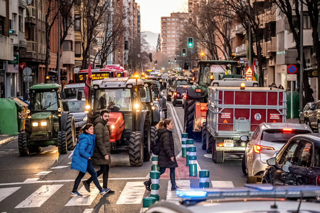 Pedestrians cross a street next to Spanish farmers with their tractors during a protest in Logrono, northern Spain, 07 February 2024. Farmers in Spain continue to protest against what they say are harmful European agricultural policies, echoing demonstrations in other parts of Europe, including Germany, Belgium and France. (Photo by Fernando Diaz/EPA/EFE)