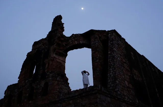 A Muslim man calls for the evening prayer after having his iftar (breaking of fast) meal during the holy month of Ramadan at the ruins of the Feroz Shah Kotla mosque in New Delhi, India, June 5, 2017. (Photo by Adnan Abidi/Reuters)