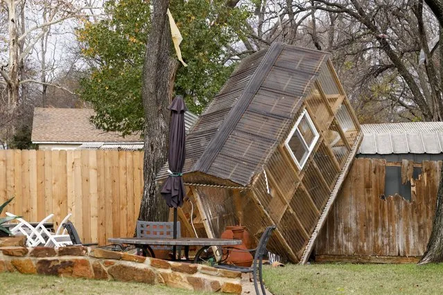 A greenhouse sits on a fence in the backyard of Randy Popiel's home after a possible tornado in Grapevine, Texas, Tuesday, December 13, 2022. (Photo by Elías Valverde II/The Dallas Morning News via AP Photo)