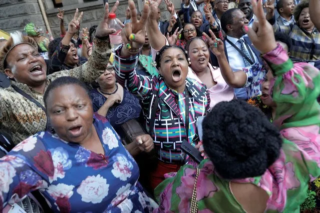 African National Congress (ANC) Members of Parliemant cheer following a vote in parliament on whether to initiate impeachment proceedings that could have forced South African President Cyril Ramaphosa out of office, at a parliamentary session in Cape Town on December 13, 2022. Ramaphosa, who was championed as a graft-busting saviour after the corruption-tainted tenure of predecessor Jacob Zuma, has been marred by accusations that he attempted to cover up a huge cash theft at his luxury farm. (Photo by Gianluigi Guercia/AFP Photo)