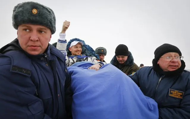 Ground personnel carry International Space Station (ISS) crew member Alexander Gerst of Germany (C) shortly after landing near the town of Arkalyk in northern Kazakhstan November 10, 2014. (Photo by Shamil Zhumatov/Reuters)