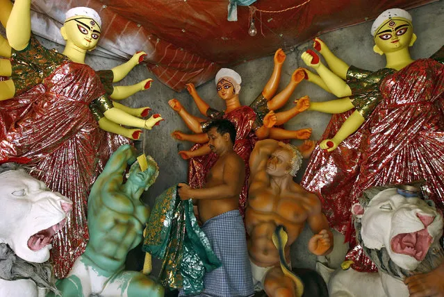 An artist adorns idols of the Hindu goddess Durga at a workshop ahead of the Durga Puja festival in Kolkata, India, October 5, 2015. The Durga Puja festival will be celebrated from October 19 to 22, which is the biggest religious event for Bengali Hindus. Hindus believe that the goddess Durga symbolises power and the triumph of good over evil. (Photo by Rupak de Chowdhuri/Reuters)