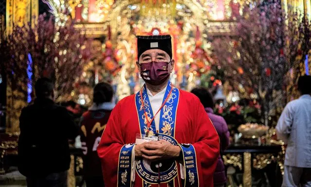 A taoist Priest attends Wong Tai Sin Temple to welcome in the Lunar New Year of the Rabbit in Hong Kong late on January 21, 2023, as people flocked to temples to pray for good luck and fortune for the new year. (Photo by Isaac Lawrence/AFP Photo)