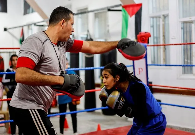 Palestinian girl Farah Abu Al-Qomsan, 15, trains with her coach, Osama Ayoub, inside the first women's boxing center in Gaza City on January 17, 2023. (Photo by Mohammed Salem/Reuters)