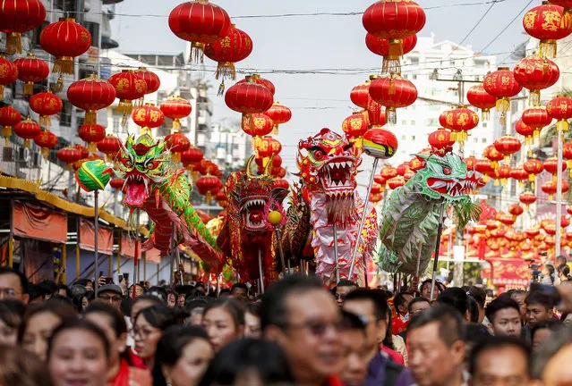 Dragon dancers march with people during Chinese Lunar New Year or Spring Festival celebration at Chinatown in Yangon, Myanmar, 16 February 2018. The Chinese New Year, the Year of the Dog, begins on 16 February 2018 and ends on 04 February 2019. (Photo by Lynn Bo Bo/EPA/EFE)