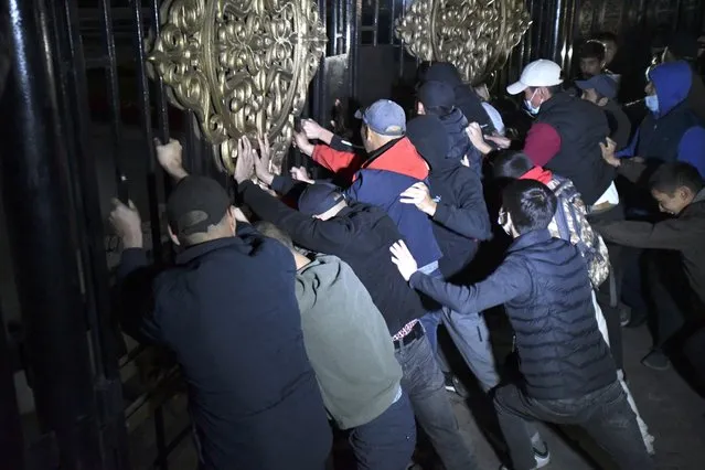 People try to storm the gate into the government headquarters during a rally against the results of a parliamentary vote in Bishkek, Kyrgyzstan, Monday, October 5, 2020. Large crowds of people have gathered in the center of Kyrgyzstan's capital to protest against the results of a parliamentary election, early results of which gave the majority of seats to two parties with ties to the ruling elites amid allegations of vote buying. (Photo by Vladimir Voronin/AP Photo)