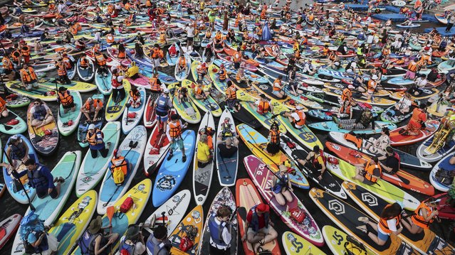 People attend a large-scale costumed Stand Up Paddleboarding (SUP) festival on the Moskva River in Moscow, Russia, 13 July 2025. (Photo by Yuri Kochetkov/EPA)