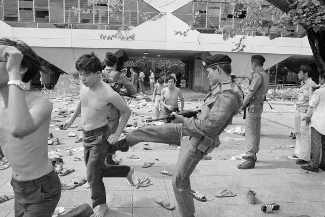 In this October 6, 1976 file photo a policeman kicks a leftist student who surrendered moments before as police moved in on Thammasat University in Bangkok, Thailand. (Photo by Neal Ulevich/AP Photo)