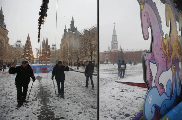 People are reflected in the enclosure of a New Year and Christmas fair in the Red Square near the Kremlin as it snows in central Moscow, December 10, 2014. (Photo by Maxim Zmeyev/Reuters)