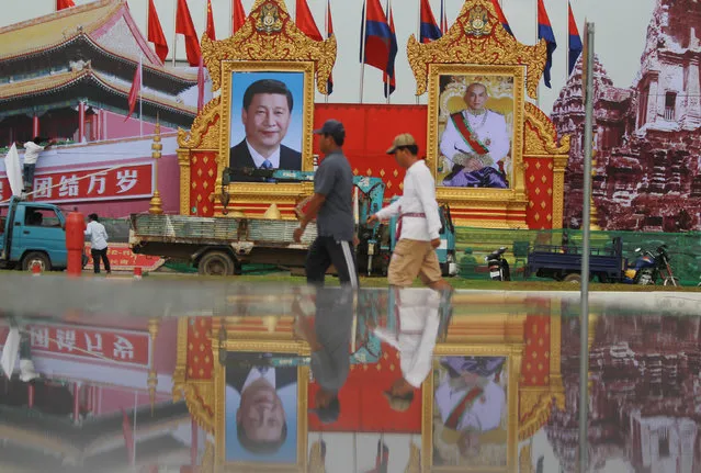 Men walk past portraits of Chinese President Xi Jinping (center, L) and Cambodian King Norodom Sihamoni ahead of his visit, in Phnom Penh, October 11, 2016. (Photo by Samrang Pring/Reuters)