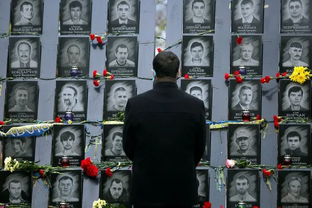 A man pays his respect at a memorial dedicated to people died in clashes with security forces at the Independent Square (Maidan) in Kiev, Ukraine, Tuesday, November 21, 2017 to mark the fourth anniversary of the beginning of the protests. People gather to commemorate the Maidan protest movement and the events which took place in late Feb. 2014 that led to the departure of former Ukrainian President Victor Yanukovich and the formation of a new government. (Photo by Efrem Lukatsky/AP Photo)
