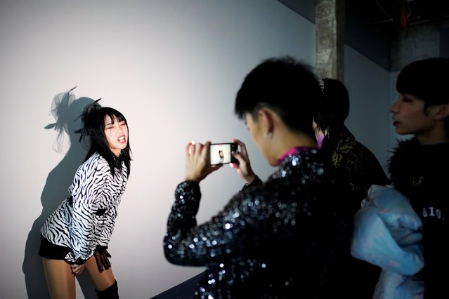 Vogue dancer Xiong Daiki, 22, takes a video of his team to promote vogue dancing, almost a year after the global outbreak of the coronavirus disease (COVID-19) in Wuhan, Hubei province, China on December 15, 2020. During lockdown, Daiki, his students and friends practiced at home in their bedrooms, staying in touch by sharing videos of new dance routines. (Photo by Aly Song/Reuters)