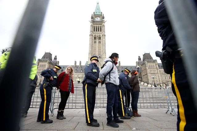 Protestors are detained after crossing a police barricade during a demonstration against the proposed Kinder Morgan pipeline on Parliament Hill in Ottawa, Ontario, Canada, October 24, 2016. (Photo by Chris Wattie/Reuters)