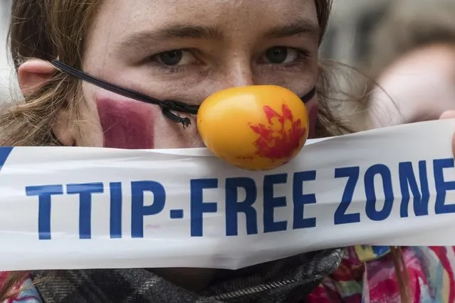 A woman protests against international trade agreements TTIP and CETA in front of EU headquarters in Brussels on Thursday, October 27, 2016. The Belgian government has reached a deal to back a free trade deal between the European Union and Canada on the day the agreement was supposed to be officially signed with Canadian Prime Minister Justin Trudeau. (Photo by Geert Vanden Wijngaert/AP Photo)