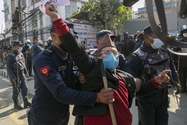 Nepalese policemen detain the human right activists during a protest against dissolution of parliament in Kathmandu, Nepal, Monday, December 21, 2020. Nepal’s president dissolved Parliament on Sunday after the prime minister recommended the move amid an escalating feud within his Communist Party that is likely to push the Himalayan nation into a political crisis. Parliamentary elections will be held on April 30 and May 10, according to a statement from President Bidya Devi Bhandari's office. (Photo by Niranjan Shrestha/AP Photo)