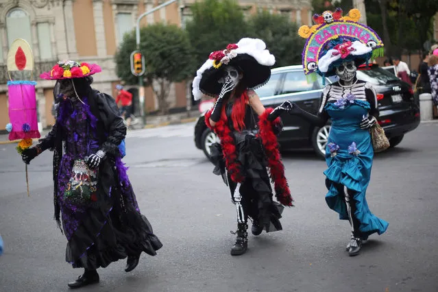 People with faces painted as popular Mexican figure “Catrina” cross the street after the annual Catrina Fest, as part of Day of the Dead celebrations, in Mexico City, Mexico, November 2, 2016. (Photo by Edgard Garrido/Reuters)