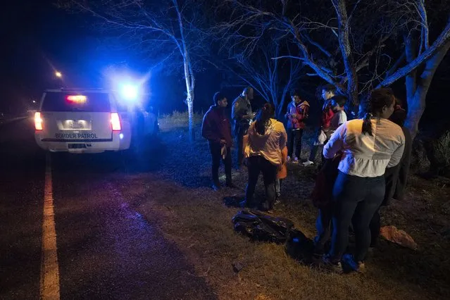 An immigration official stops a group of migrants from Central America as they walk on a road after they crossed the Texas-Mexico border, Friday, May 12, 2023, in Fronton, Texas. (Photo by Julio Cortez/AP Photo)