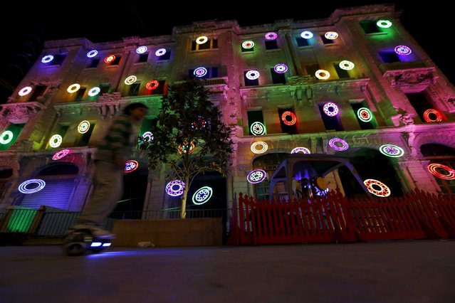 A boy rides a two-wheeled self-balancing scooter near to a war-ravaged building decorated for Christmas, in downtown Beirut, Lebanon December 5, 2015. (Photo by Jamal Saidi/Reuters)