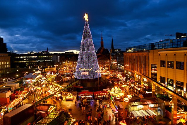 The traditional 45 meter Dortmund Christmas tree, one of the world's largest, is illuminated at the Christmas market in Dortmund, western Germany, on November 28, 2024. (Photo by Ina Fassbender/AFP Photo)
