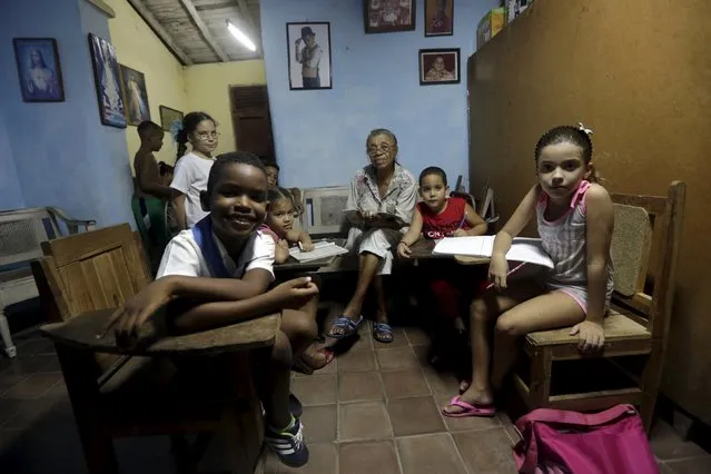 Arelis (C), 74, a tutor, sits with her students in her house in Camaguey province, Cuba November 12, 2015. Picture taken November 12, 2015. (Photo by Enrique de la Osa/Reuters)