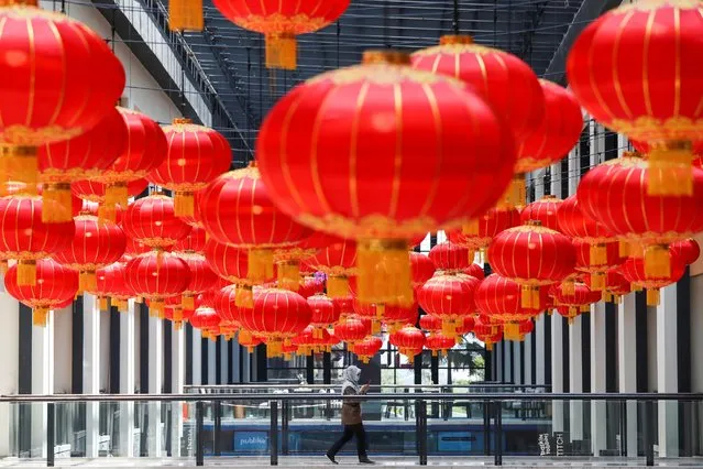 A woman wearing a protective mask walks past Lunar New Year decoration at a shopping mall in Kuala Lumpur, Malaysia on February 10, 2021. (Photo by Lim Huey Teng/Reuters)