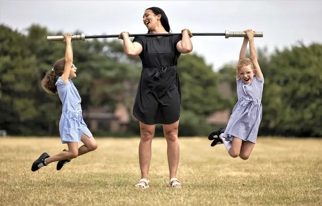 Hannah Lewis, a European masters weightlifting champion and teacher, practises with her year 3 pupils on the school playing fields in United Kingdom in the last decade of June 2023. She has qualified for the World Masters Weightlifting Championships in Poland in August, but needs to raise the funds to get there. (Photo by Corin Messer/BNPS)