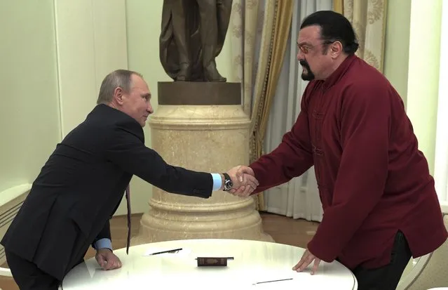 Russian President Vladimir Putin shakes hands with U.S. actor Steven Seagal in the Kremlin in Moscow,Friday, November 25, 2016. Putin has given a Russian passport to Seagal, a regular visitor to Russia in recent years, calling it a sign of a thaw in relations between the two countries. (Photo by Alexei Druzhinin/Sputnik, Kremlin Pool Photo via AP Photo)