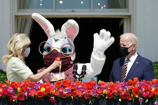 U.S. President Joe Biden stands to deliver his remarks on the tradition of Easter, next to first lady Jill Biden holding a flower and a person wearing an Easter Bunny costume  at the Blue Room Balcony of the White House in Washington, U.S. April 5, 2021. (Photo by Kevin Lamarque/Reuters)
