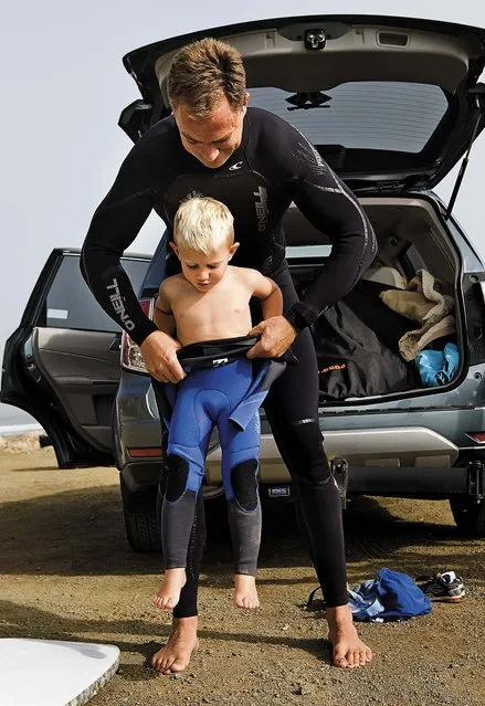 Triston Gailey, 3, gets some help squeezing into his wetsuit from his father, Todd, before hitting the waves in Morro Bay, California. (Photo by Joe Johnston/The Tribune of San Luis Obispo)
