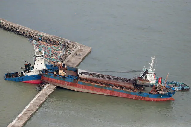 An aerial view from a Jiji Press helicopter shows a ship that collided with a breakwater due to strong winds caused by typhoon Jebi in Nishinomiya city, Hyogo prefecture on September 5, 2018. The toll in the most powerful typhoon to hit Japan in a quarter century rose on September 5 to nine, with thousands stranded at a major airport because of storm damage. (Photo by AFP Photo/JIJI Press)