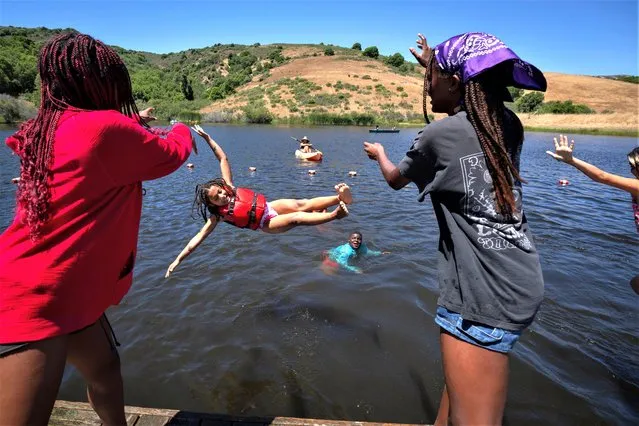 Maya Johnson, 7, of New York, is playfully swung into the lake by her friends during Camp Be'chol Lashon, a sleepaway camp for Jewish children of color, Friday, July 28, 2023, in Petaluma, Calif., at Walker Creek Ranch. (Photo by Jacquelyn Martin/AP Photo)