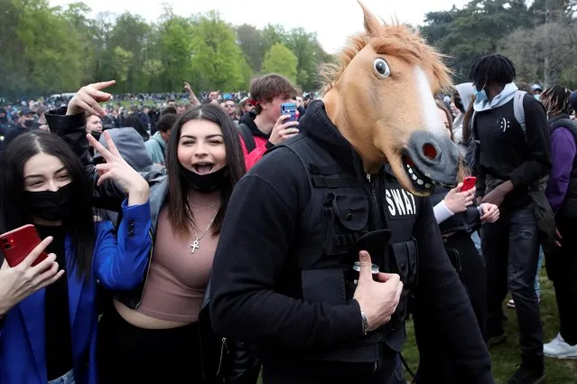 A person wears a horse mask as people gather at the Bois de la Cambre/Ter Kamerenbos park for a party called “La Boum 2” in defiance of Belgium's coronavirus disease (COVID-19) social distancing measures and restrictions, in Brussels, Belgium on May 1, 2021. (Photo by Yves Herman/Reuters)