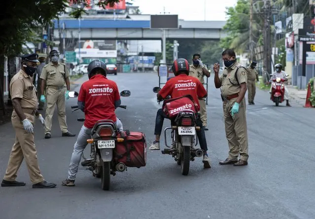 Policemen check the credentials of food delivery personnel during a lockdown imposed to curb the spread of coronavirus in Kochi, Kerala state, India, Saturday, May 8, 2021. Kerala, which emerged as a blueprint for tackling the pandemic last year, began a lockdown on Saturday. (Photo by R.S. Iyer/AP Photo)