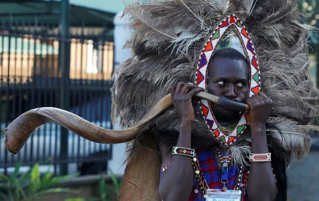 A delegate from the indigenous Maasai community blows a horn and wears an ostrich feathers headgear as he arrives for the Africa Climate Summit (ACS) 2023 at the Kenyatta International Convention Centre (KICC) in Nairobi, Kenya on September 6, 2023. (Photo by Monicah Mwangi/Reuters)