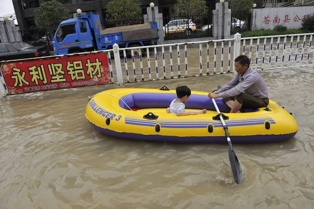 Residents make their way through a flooded street on an inflatable boat in disaster-hit Cangnan county of Wenzhou, east China's Zhejiang province,  on October 7, 2013, where more than 1,200 homes collapsed and damages amounted to hundreds of millions of yuan. Typhoon Fitow barrelled into China's east coast, packing winds of more than 200 kilometres (125 miles) an hour, after hundreds of thousands of people were evacuated and bullet train services were suspended. At least three people were reported killed, all of them near the city of Wenzhou in Zhejiang province, the state broadcaster CCTV said. (Photo by AFP Photo)