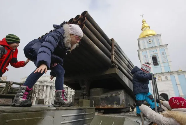 Children play on a BM-21 Grad multiple rocket launcher system during the opening of an exhibition displaying military weapons and vehicles seized from pro-Russian separatists during fighting in eastern Ukraine, in central Kiev February 21, 2015. The exhibit shows military weapons which are of Russian origin, according to organizer Ukraine's Presidential Administration. REUTERS/Valentyn Ogirenko  (UKRAINE - Tags: CIVIL UNREST MILITARY)