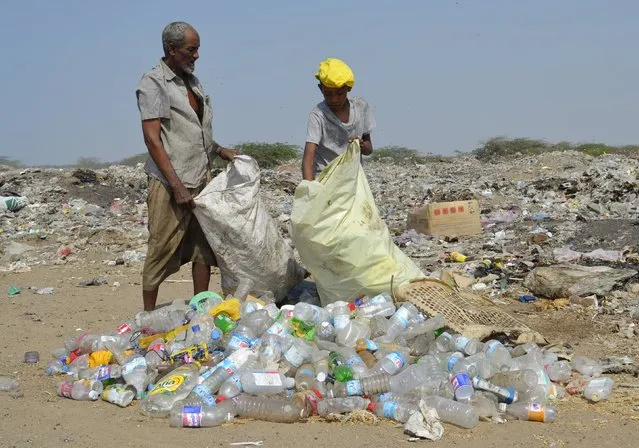 A man and a boy collect recyclable waste at a rubbish dump outside Yemen's Red Sea port city of Houdieda January 19, 2016. (Photo by Abduljabbar Zeyad/Reuters)