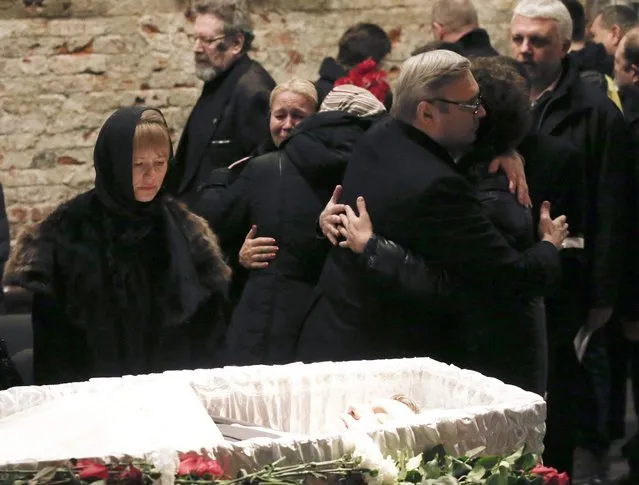 Mourners, including Mikhail Kasyanov (R, front), an opposition leader and Russian former Prime Minister, comfort each other as they attend a memorial service before the funeral of Russian leading opposition figure Boris Nemtsov in Moscow, March 3, 2015. Several hundred Russians, many carrying red carnations, queued on Tuesday to pay their respects to Nemtsov, the Kremlin critic whose murder last week showed the hazards of speaking out against Russian President Vladimir Putin. REUTERS/Maxim Zmeyev 