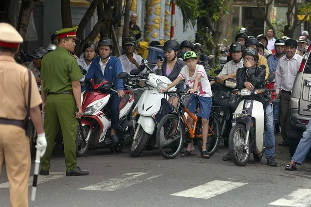 Vietnamese security officials stop traffic along a side street for an official motorcade in Danang, Vietnam, Friday, November 10, 2017, ahead of the arrival of U.S. President Donald Trump to attend the Asia-Pacific Economic Cooperation (APEC) Summit. (Photo by Mark Schiefelbein/AP Photo)
