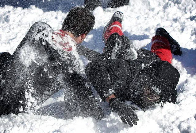 A man tackles another man as they participate in a snowball fight at Dupont Circle January 24, 2016 in Washington, DC. (Photo by Alex Wong/Getty Images)