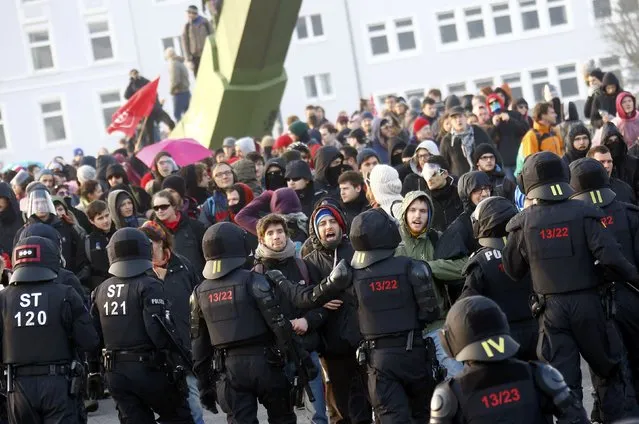 Policemen stand in front of “Blockupy” anti-capitalist protesters near the European Central Bank (ECB) building before the official opening of its new headquarters in Frankfurt March 18, 2015. (Photo by Kai Pfaffenbach/Reuters)