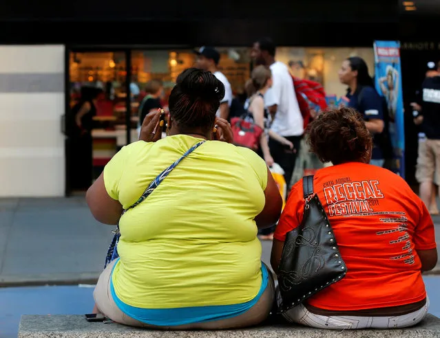 Women sit on a bench in New York City's Times Square, NY, U.S. May 31, 2012. (Photo by Brendan McDermid/Reuters)