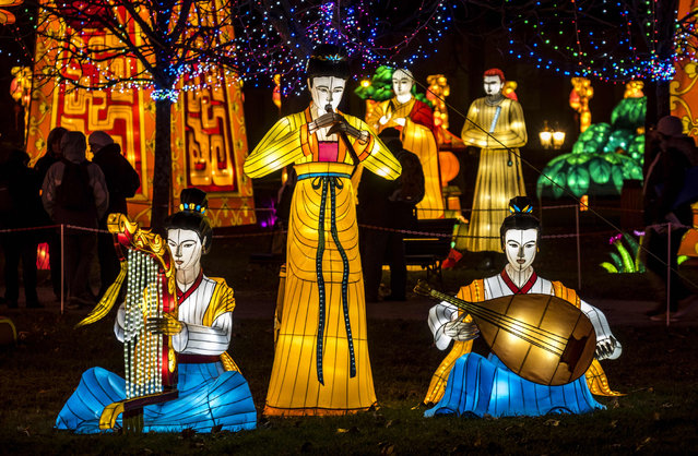 Visitors look at giant lanterns installed at the Foucaud Park in Gaillac, southwestern France, on the occasion of the Lantern Festival, on December 12, 2018. Monumental silk sculptures are exhibited in Gaillac from December 1, 2018 to February 6, 2019, as part of the Chinese traditional Lantern Festival marking the end of celebrations for the Chinese Lunar New Year period. (Photo by Eric Cabanis/AFP Photo)