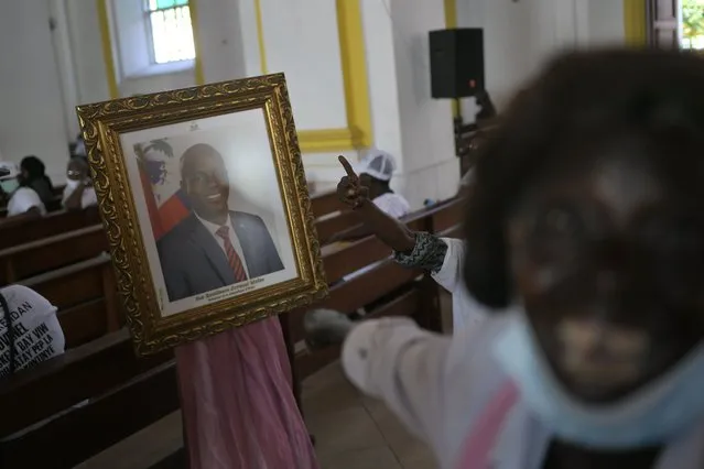 People call for justice as they point to a portrait of the late President Jovenel Moïse during a memorial service for him in the Cathedral of Cap-Haitien, Haiti, Thursday, July 22, 2021. Moïse was killed in his home on July 7. (Photo by Matias Delacroix/AP Photo)