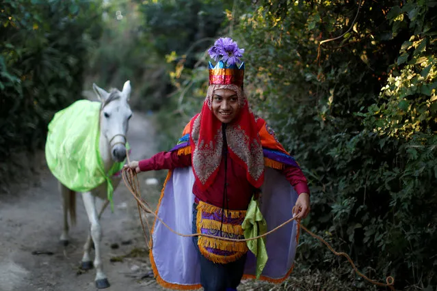 A member of the traditional group of “Los Historiantes” pulls a horse during a walk around the neighborhood of San Antonio Abad to celebrate the Three Kings Day holiday in San Salvador, El Salvador on January 6, 2019. (Photo by Jose Cabezas/Reuters)
