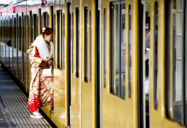 A Japanese woman wearing a kimono gets on a train after the Coming of Age Day celebration in Tokyo, Japan January 9, 2017. (Photo by Kim Kyung-Hoon/Reuters)