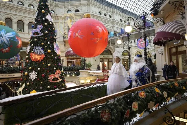 Actors dressed as Ded Moroz, Grandfather Frost, the Russian Santa Claus and Snegurochka, Snow Maiden walk inside the GUM department store, decorated for Christmas and New Year festivities, in Moscow, Russia, Wednesday, November 22, 2023. (Photo by Alexander Zemlianichenko/AP Photo)
