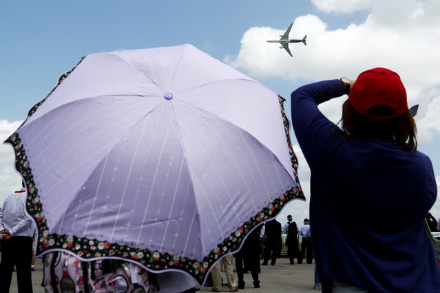 Attendees watch an Airbus A350 aircraft manufactured by Airbus SAS perform maneuvers during a flying display at the Singapore Airshow held at the Changi Exhibition Centre in Singapore, on Tuesday, February 16, 2016. Airbus's and Boeings Co.'s 20-year outlooks are dependent on Asia Pacific for new fleet sales, with estimates that 39 percent of their total deliveries will be to that region through 2034. (Photo by SeongJoon Cho/Bloomberg)