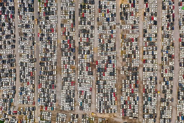 This aerial photo taken on August 10, 2021 shows vehicles damaged by floods in July at a parking lot, some of which will be discarded, in Zhengzhou in China's central Henan province. (Photo by AFP Photo/China Stringer Network)